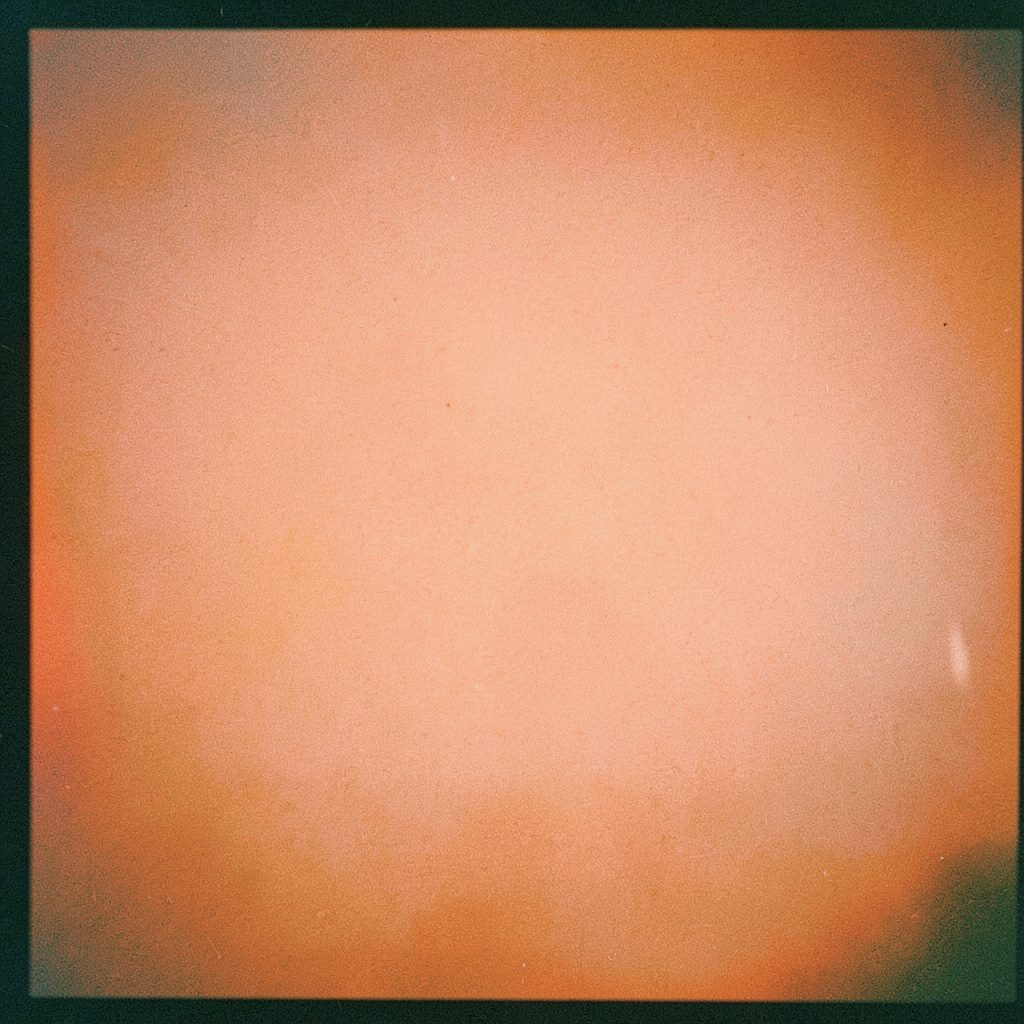 Analog photograph of small smart home devices arranged on a white shelf, soft pastel blues and creams, bright diffused daylight, gentle film grain